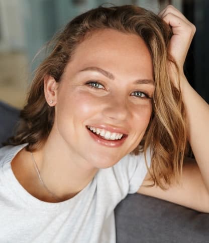 Young woman smiling with healthy teeth protected by dental sealants
