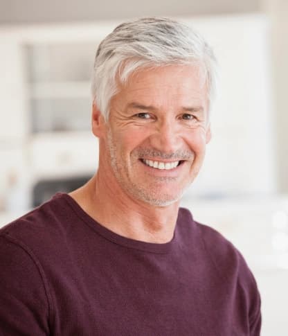 Smiling older man with a confident smile restored by dental implants
