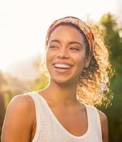 Smiling woman outdoors, pain-free after root canal therapy
