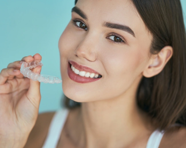 Smiling woman with Invisalign clear aligners