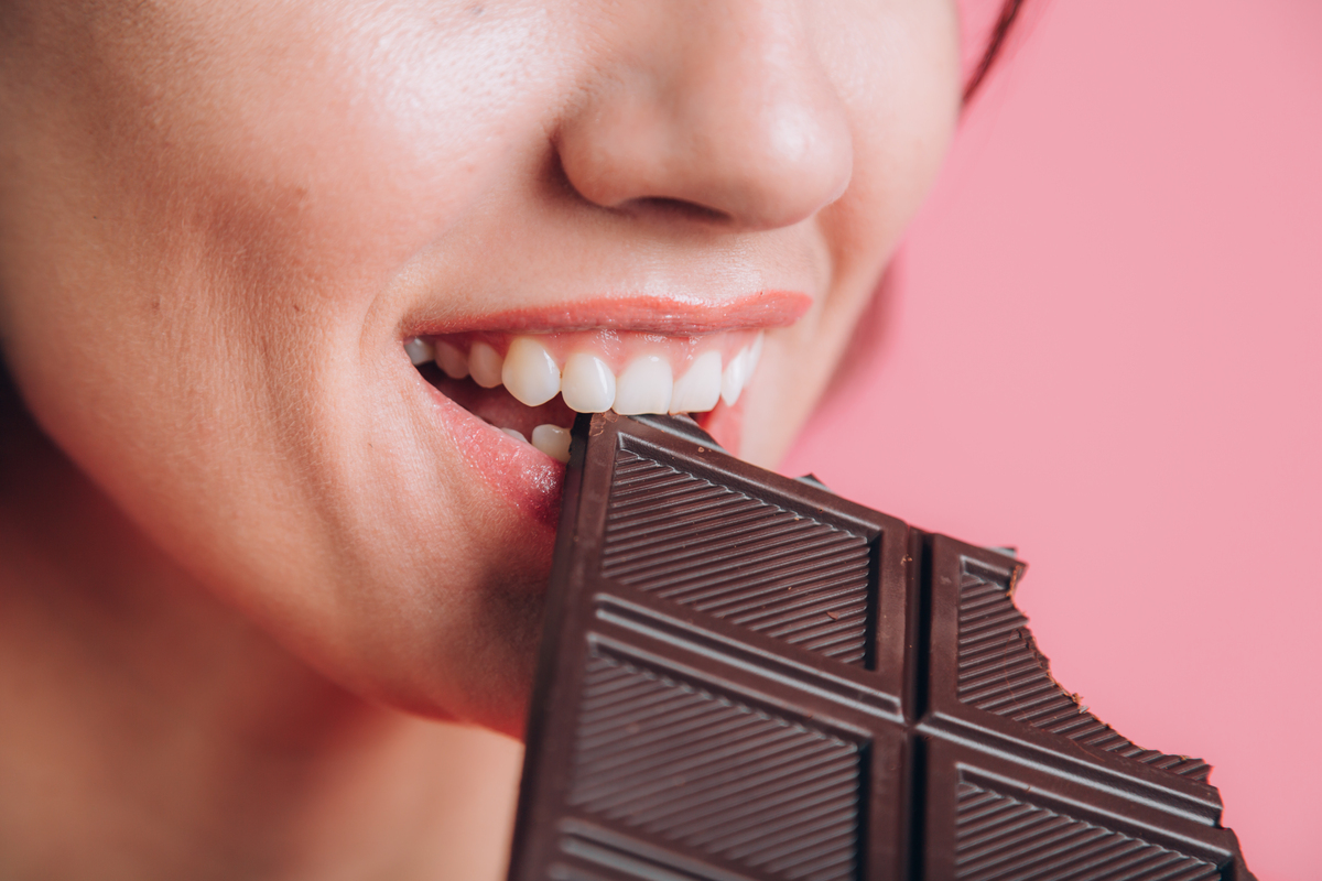 Woman enjoying dark chocolate as a tooth-friendly treat